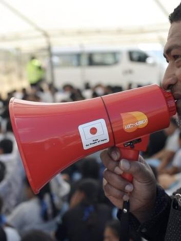 Man holding a megaphone speaking into a crowd
